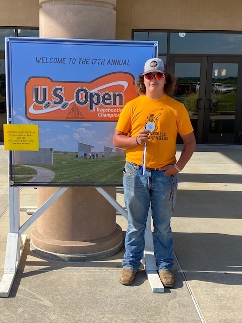 Student with medal in front of US Open sign