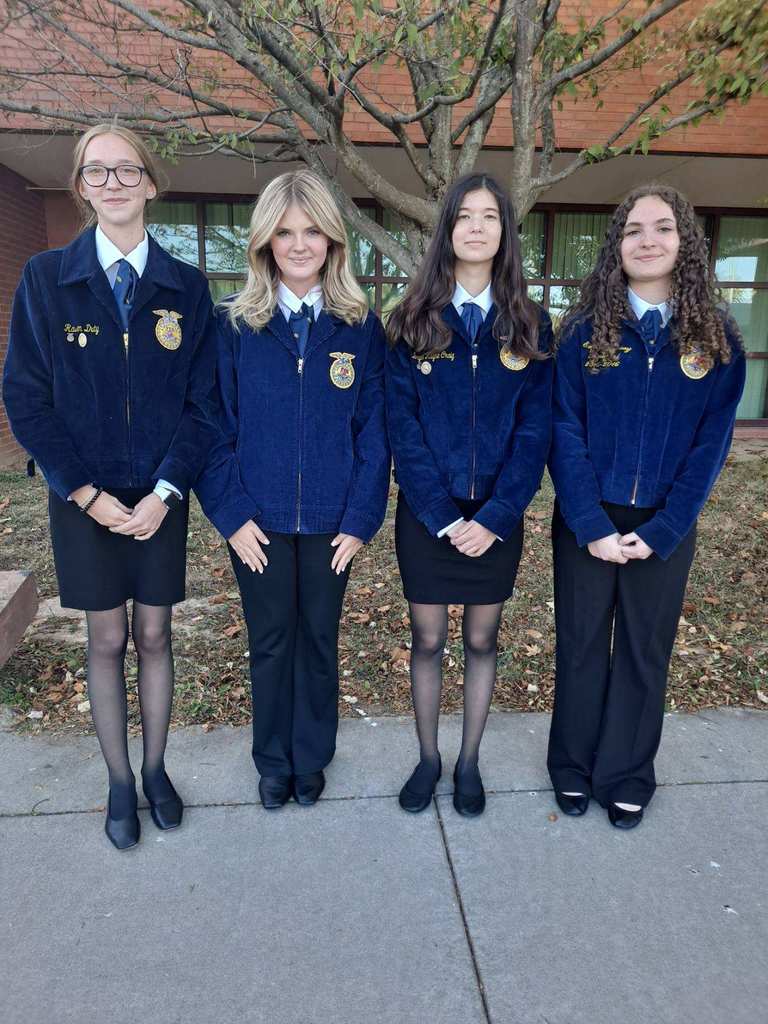 Four young women in navy blue FFA jackets